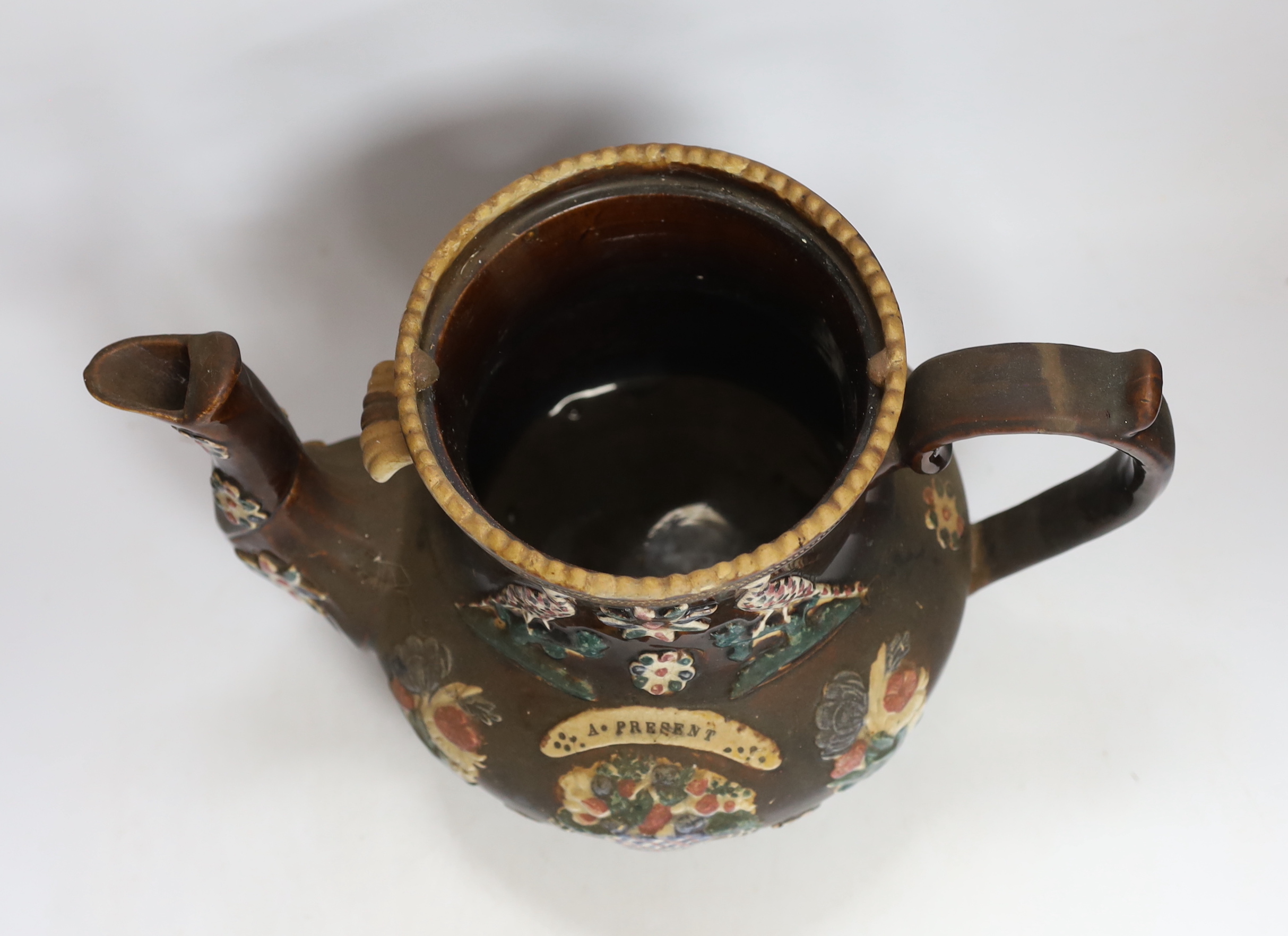 A Measham Barge ware glazed pottery teapot, decorated in relief, 35cm wide